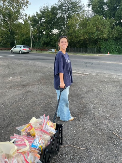A volunteer pulling a wagon full of snack kits